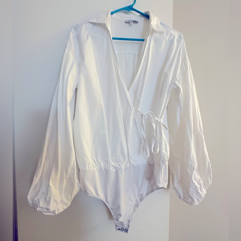 Large, white puffy long sleeve tie up bodysuit.